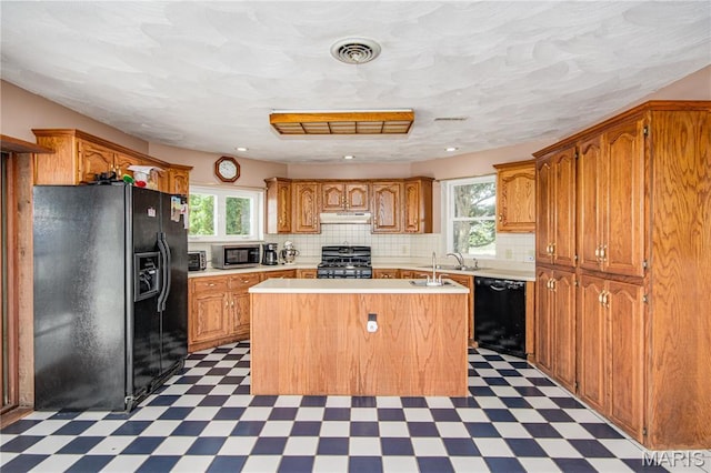 634 N 200th St, Vandalia, IL 62471 - kitchen featuring black appliances, tile patterned floors, under cabinet range hood, and healthy amount of natural light