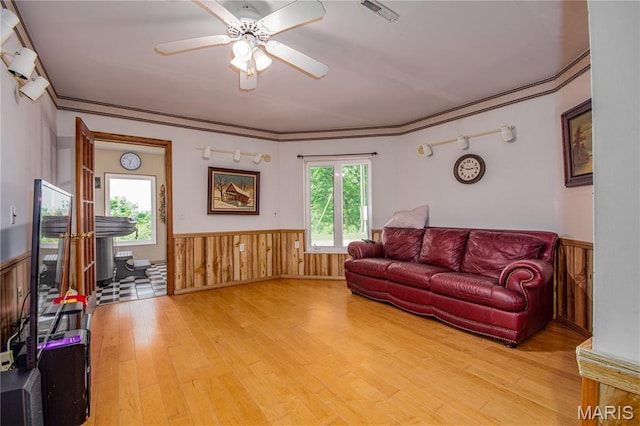 634 N 200th St, Vandalia, IL 62471 - living room featuring wainscoting, healthy amount of natural light, light wood finished floors, ceiling fan, and wooden walls