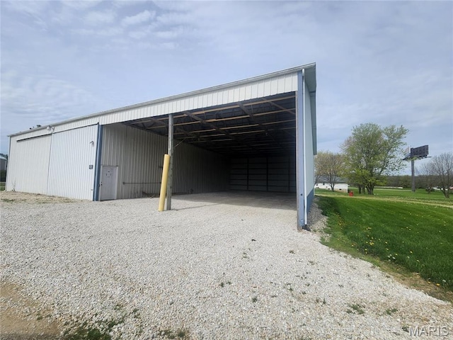 view of pole building with gravel driveway and a lawn