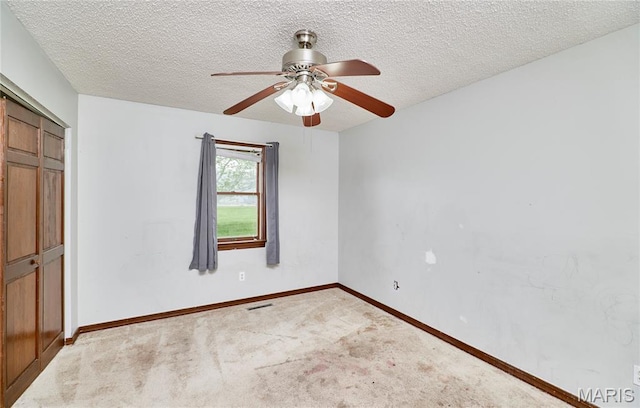 unfurnished bedroom featuring a closet, carpet floors, baseboards, a textured ceiling, and a ceiling fan