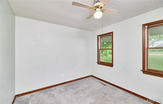 empty room featuring carpet, baseboards, a ceiling fan, and a textured ceiling