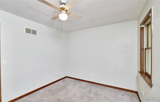 unfurnished room with carpet floors, a textured ceiling, baseboards, and ceiling fan