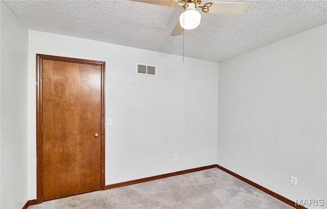 spare room with carpet flooring, a textured ceiling, a ceiling fan, and baseboards