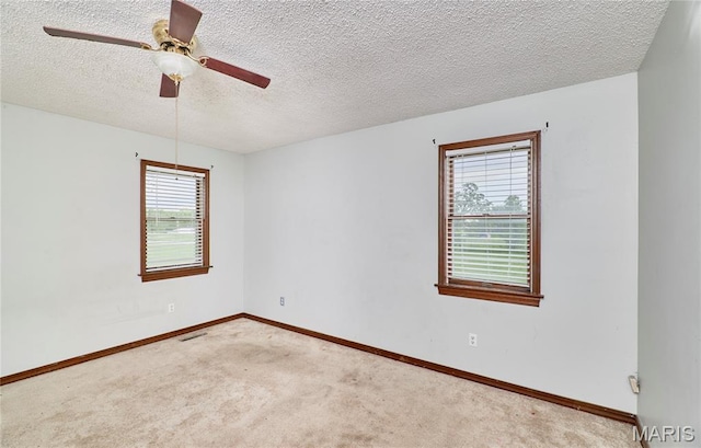 unfurnished room featuring carpet flooring, ceiling fan, baseboards, and a textured ceiling