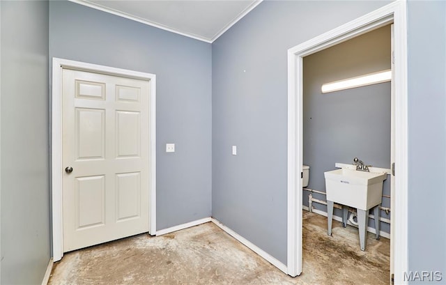 foyer featuring ornamental molding, baseboards, and concrete floors