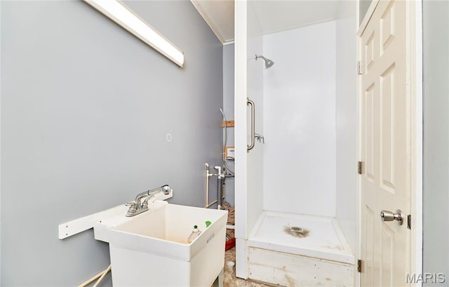 bathroom with a shower stall and a sink