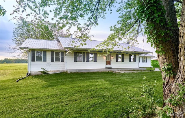 single story home with a front yard and metal roof