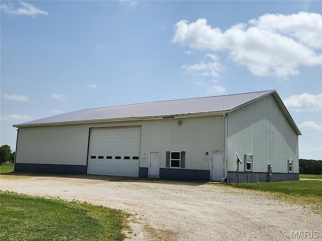 view of home's exterior featuring an outdoor structure, a garage, and metal roof