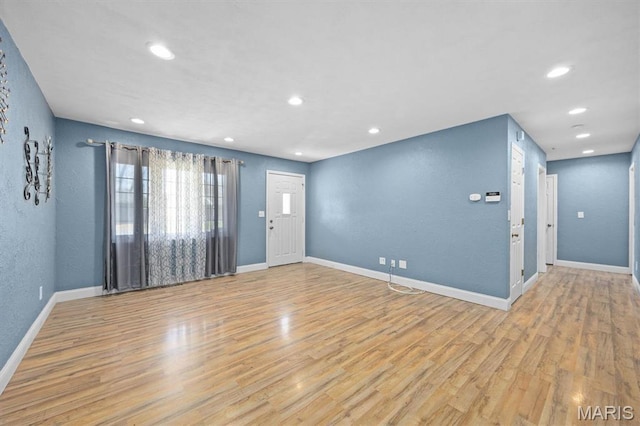 unfurnished living room featuring light wood-type flooring, recessed lighting, and baseboards