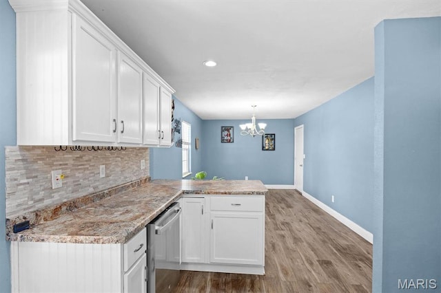 kitchen with stainless steel dishwasher, a chandelier, light wood-style flooring, white cabinetry, and recessed lighting