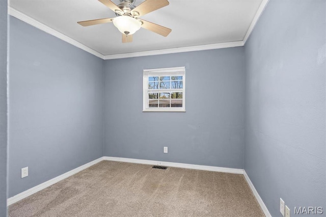 carpeted empty room featuring baseboards, ornamental molding, and a ceiling fan