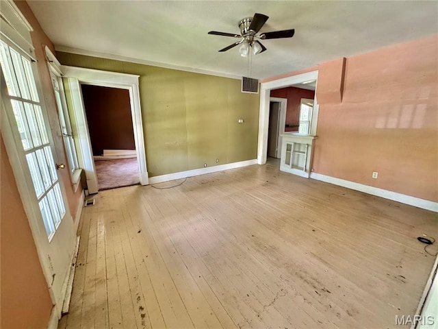 empty room with baseboards, a ceiling fan, and light wood-style floors