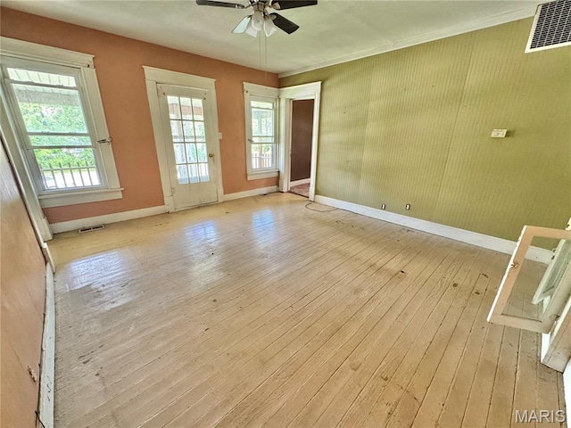 spare room featuring light wood-style floors, baseboards, and a ceiling fan