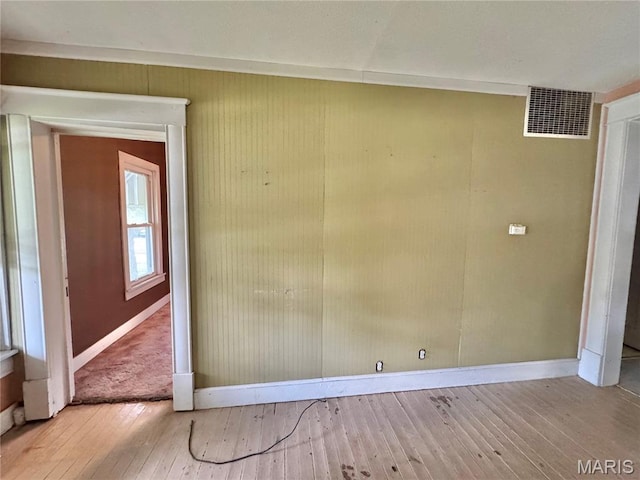 unfurnished room featuring wood-type flooring and baseboards