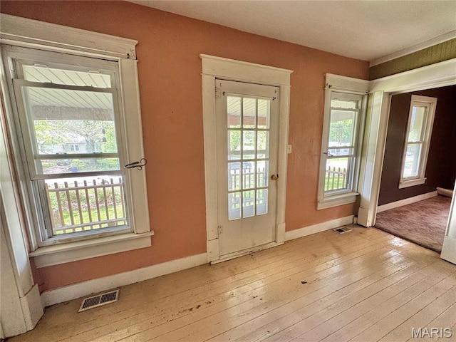 doorway to outside with healthy amount of natural light, hardwood / wood-style floors, and baseboards