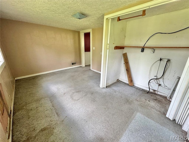 washroom featuring a textured ceiling, carpet flooring, and baseboards