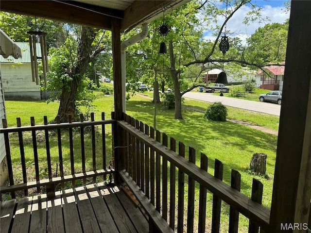 wooden deck featuring a lawn