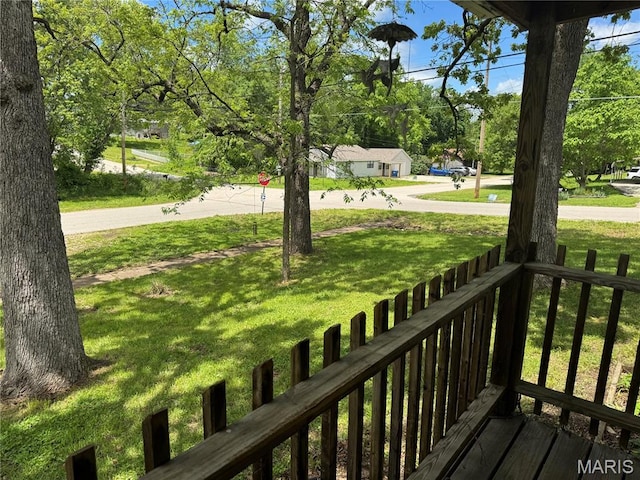 wooden terrace featuring a lawn