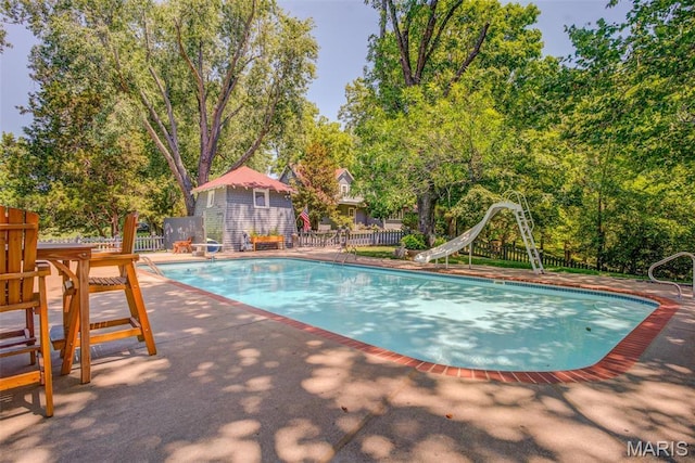 1577 Kehrs Mill Rd, Chesterfield, MO 63005 - view of pool featuring a water slide, fence, a patio, and view of wooded area