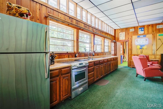 1577 Kehrs Mill Rd, Chesterfield, MO 63005 - kitchen with stainless steel appliances, dark colored carpet, a sink, wood walls, and light countertops