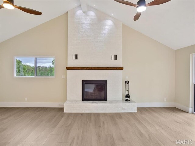 unfurnished living room with ceiling fan, light wood finished floors, baseboards, and high vaulted ceiling