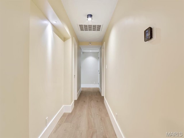 hallway with light wood-style floors and baseboards