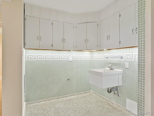laundry room with a sink and tile walls