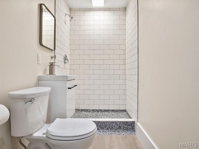 full bath featuring toilet, a shower stall, and wood finished floors