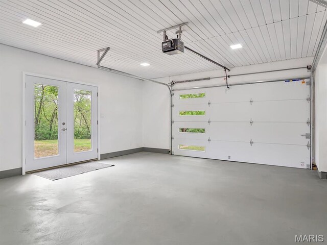 garage with french doors, a garage door opener, and baseboards