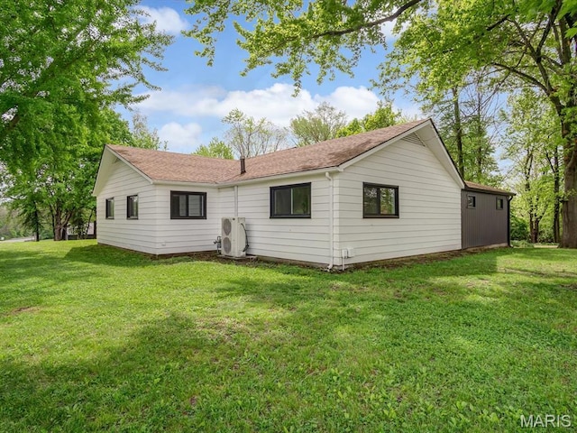 rear view of property featuring a cooling unit and a lawn