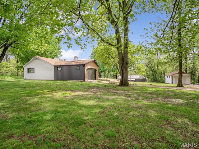 view of grassy yard with an outdoor structure