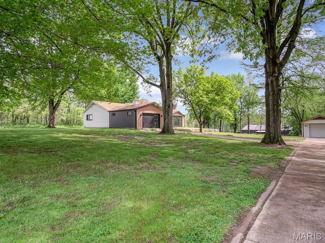 view of grassy yard with concrete driveway