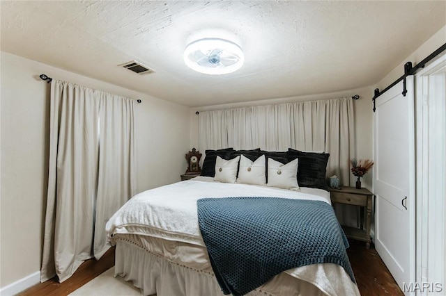 631 State Route T, Newburg, MO 65550 - bedroom featuring wood finished floors, a barn door, and baseboards