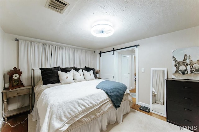 631 State Route T, Newburg, MO 65550 - bedroom featuring a barn door, wood finished floors, and baseboards