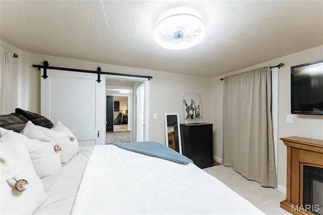 631 State Route T, Newburg, MO 65550 - bedroom with a barn door, light colored carpet, a textured ceiling, and baseboards