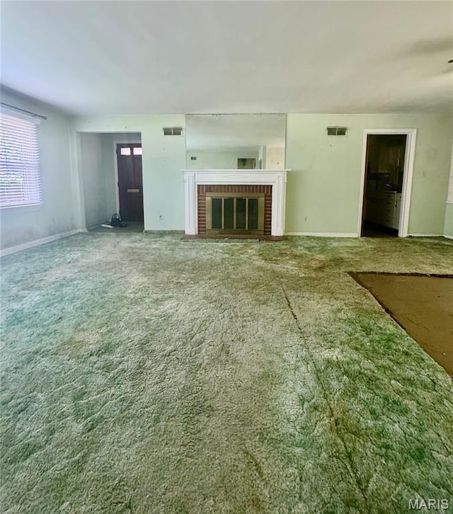 1709 Korando Ave, Saint Louis, MO 63114 - unfurnished living room featuring carpet and a brick fireplace