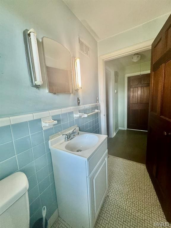 1709 Korando Ave, Saint Louis, MO 63114 - bathroom featuring vanity, wainscoting, tile walls, and tile patterned flooring