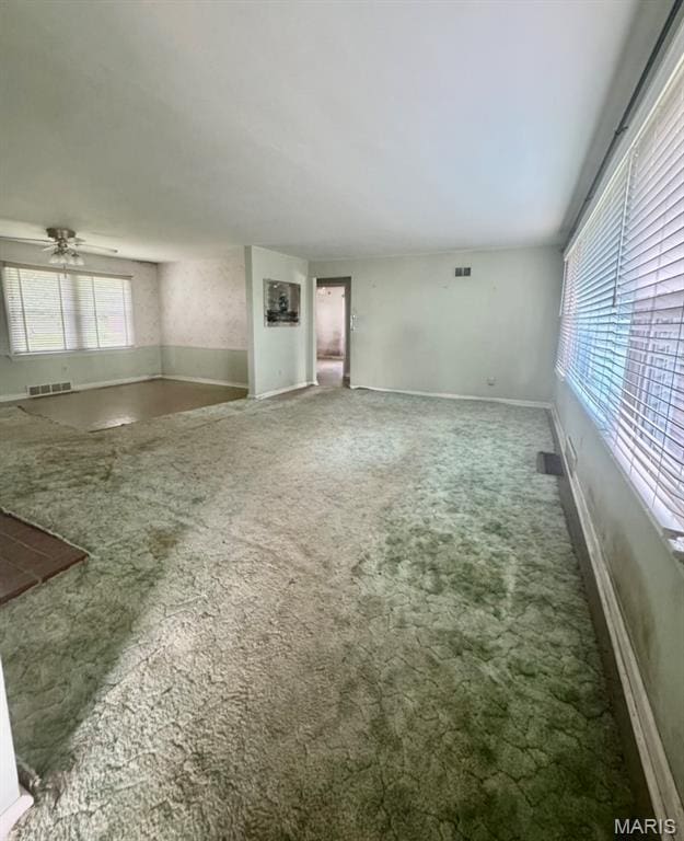 1709 Korando Ave, Saint Louis, MO 63114 - unfurnished living room featuring carpet and ceiling fan