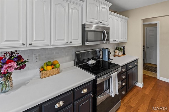 kitchen with appliances with stainless steel finishes, white cabinets, light wood-style flooring, and light countertops