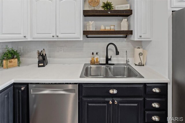 kitchen featuring dishwasher, a sink, white cabinetry, and dark cabinets