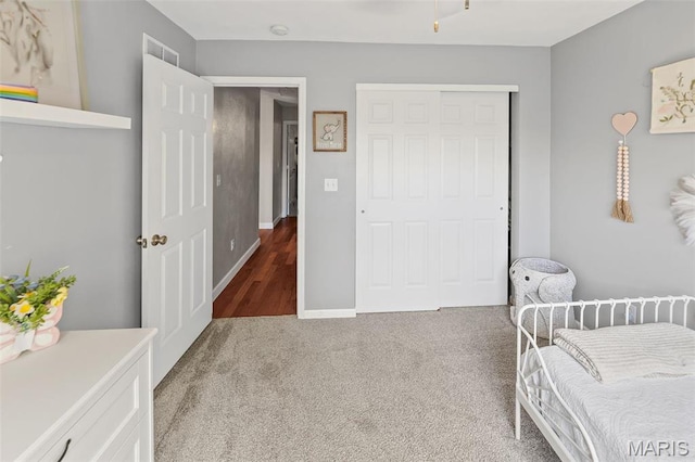 bedroom with a closet, carpet floors, and baseboards