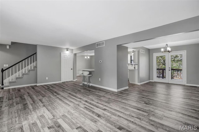 1211 Napoleon Dr, Bonne Terre, MO 63628 - unfurnished living room featuring wood finished floors, a chandelier, baseboards, and stairway