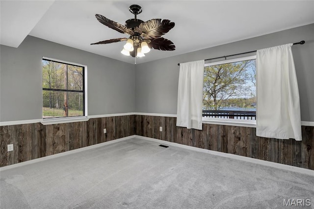1211 Napoleon Dr, Bonne Terre, MO 63628 - unfurnished room with carpet floors, wood walls, a wainscoted wall, a ceiling fan, and baseboards