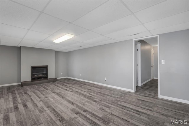 1211 Napoleon Dr, Bonne Terre, MO 63628 - unfurnished living room featuring a paneled ceiling, wood finished floors, baseboards, and a glass covered fireplace