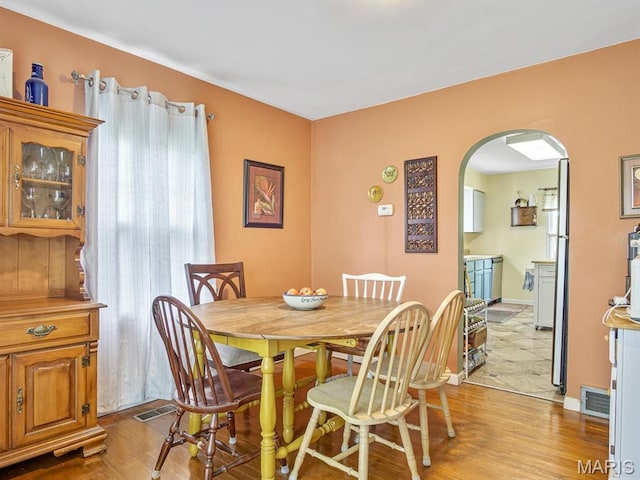 126 Sunset Ave, Collinsville, IL 62234 - dining room featuring arched walkways, light wood-style flooring, and baseboards