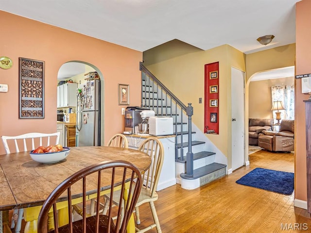 126 Sunset Ave, Collinsville, IL 62234 - dining space with arched walkways, light wood finished floors, and stairway