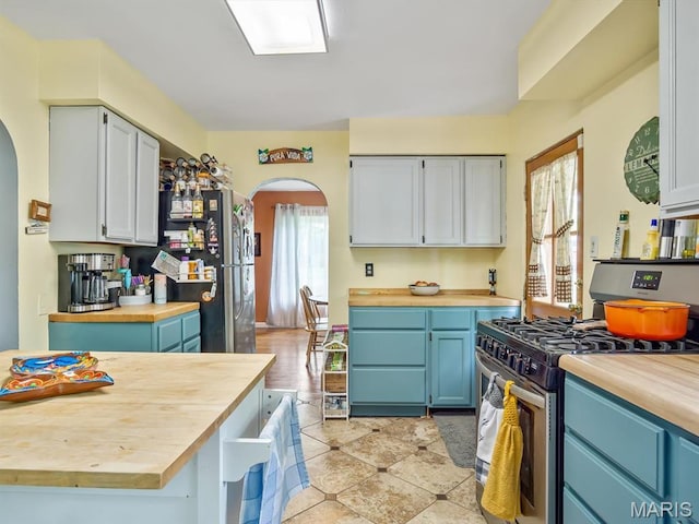 126 Sunset Ave, Collinsville, IL 62234 - kitchen with butcher block countertops, appliances with stainless steel finishes, arched walkways, and blue cabinets