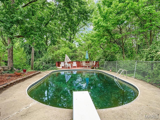 126 Sunset Ave, Collinsville, IL 62234 - view of swimming pool featuring fence, a patio, a diving board, and view of wooded area