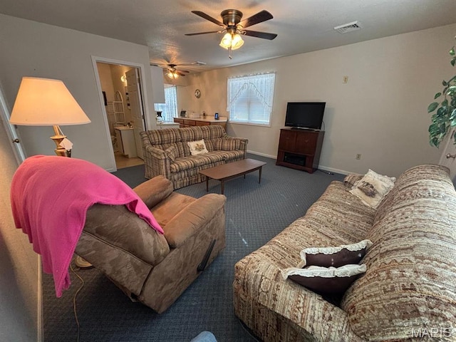 carpeted living room featuring a ceiling fan and baseboards