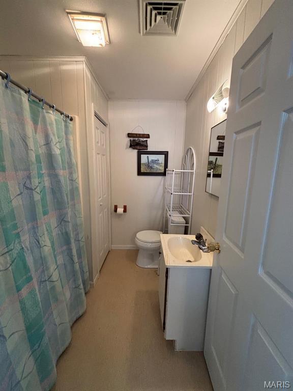 full bath with toilet, vanity, and baseboards